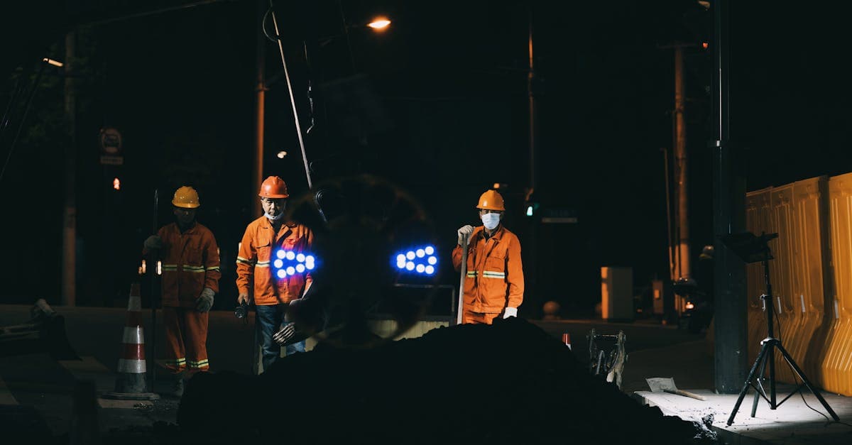 Field worker in a high-visibility vest clocking in on a mobile phone at a work site