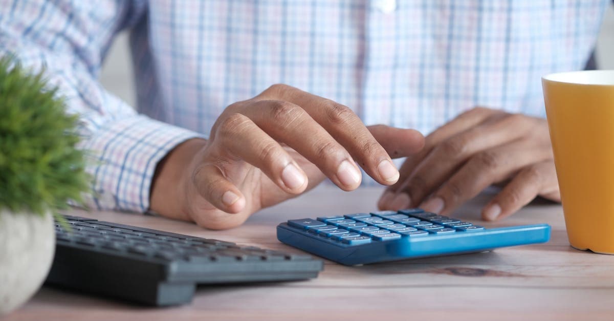 Checklist on a desk next to a laptop showing financial reports